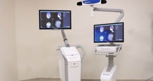 Advanced medical imaging equipment with dual monitors displaying brain scans in a clinical setting.